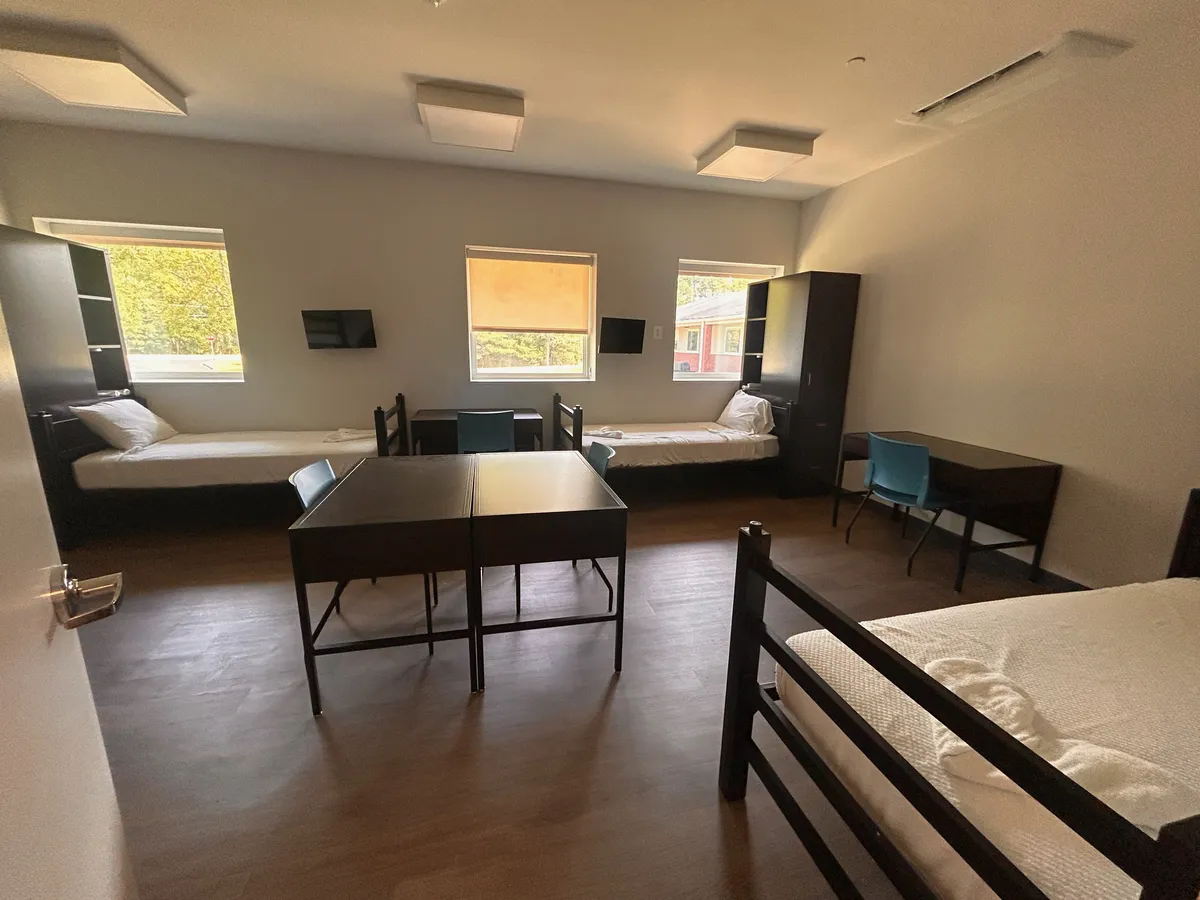 Shared client bedroom with two beds and a table at Still Detox New Jersey