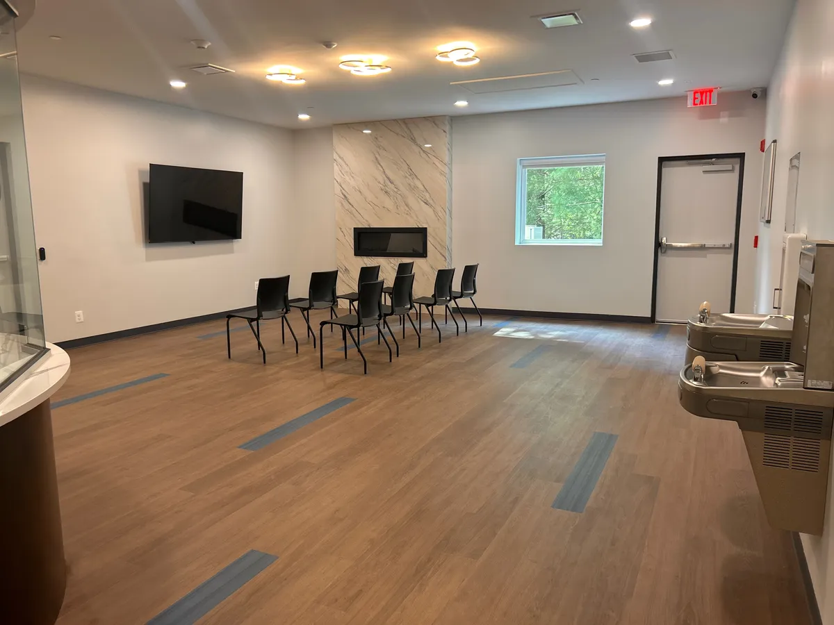 Client lounge with a television and fireplace wall at Still Detox New Jersey