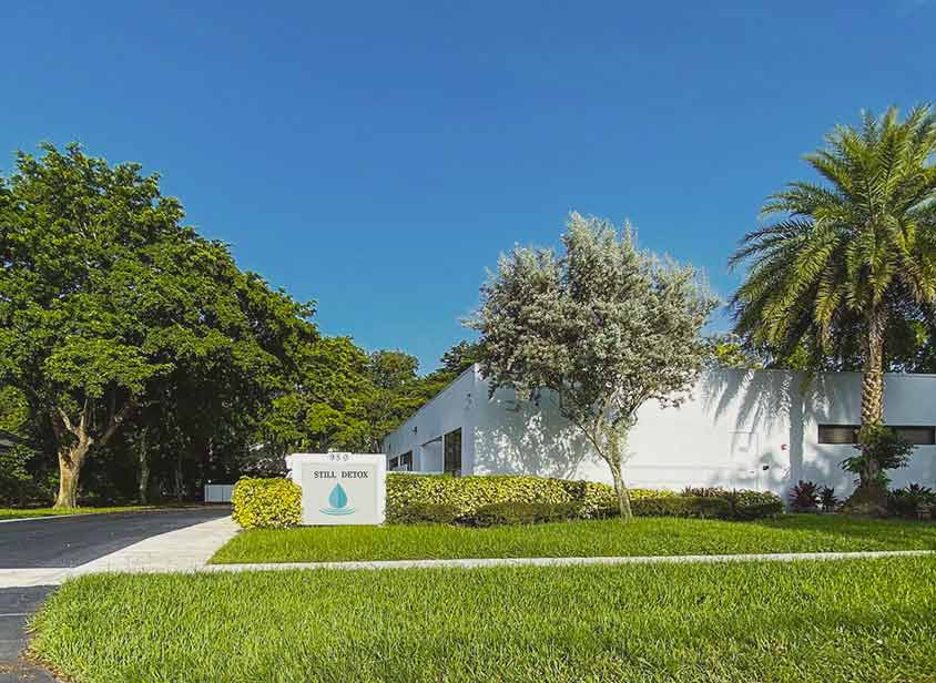 Exterior of the Still Detox medical detox center with its droplet-logo sign on a landscaped lawn in Boca Raton, Florida